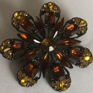Vintage metal and rhinestone pin.  2" diameter.